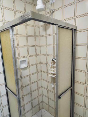 a shower with a glass door in a bathroom at 11Suites casa Suite #6 in Caraguatatuba
