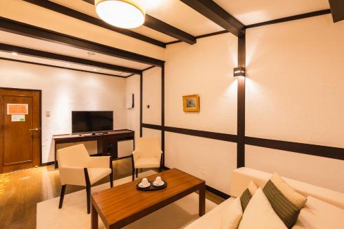 a living room with a couch and a table at Hotel Jogakura in Aomori