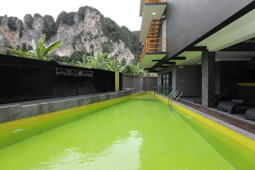 a swimming pool with green water in front of a building at Aspira Escape Ao Nang Krabi in Ao Nang Beach