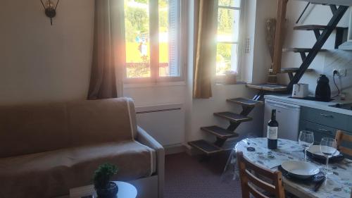 - un salon avec une table, un canapé et une fenêtre dans l'établissement Bienvenue au Palace Riviera, à Menton