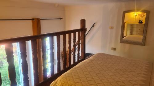 - une chambre avec un escalier, un lit et un miroir dans l'établissement Bienvenue au Palace Riviera, à Menton