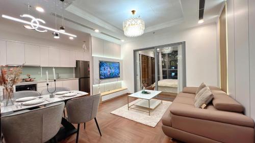 a living room and kitchen with a couch and a table at KABILUX HOUSE - 1-2-3 Bedrooms in Vinhomes Times City in Hanoi