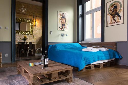 Un dormitorio con una cama azul y una mesa. en New - WalnutTree Double 12 Person Apartment central in Budapest - Hungary, en Budapest