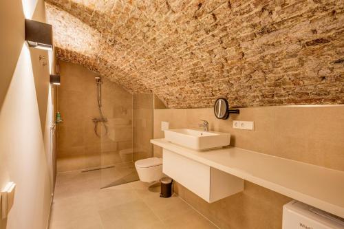 a bathroom with a sink and a stone wall at Luxurious renovated apartment in Utrecht City center with view on the old canal in Utrecht