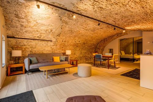 a living room with a couch and a brick wall at Luxurious renovated apartment in Utrecht City center with view on the old canal in Utrecht