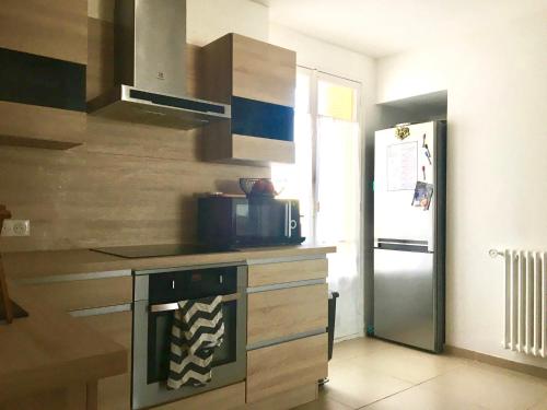 une cuisine avec une cuisinière et un réfrigérateur dans l'établissement Cosy 70m terrasses- Clim - Nice centre Libération, à Nice