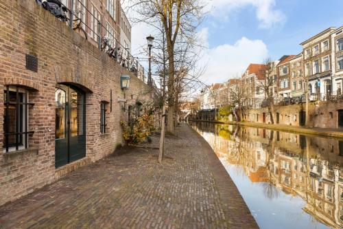 a canal in a city with buildings and a tree at Luxurious renovated apartment in Utrecht City center with view on the old canal in Utrecht