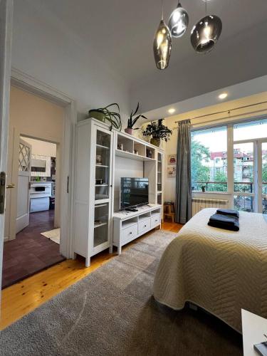 a bedroom with a white cabinet and a television at Christine's Apartment in Sofia