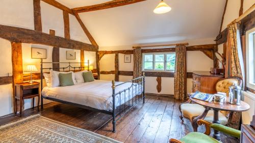 a bedroom with a bed in a room with wooden floors at Coppice House in Ashton under Hill