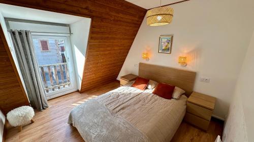 Un dormitorio con una cama y una ventana grande en Les Oréades Le Mont Dore 10pers, en Le Mont-Dore