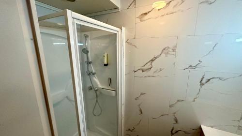 baño con ducha a ras de suelo junto a una puerta de cristal en Les Oréades Le Mont Dore 10pers, en Le Mont-Dore