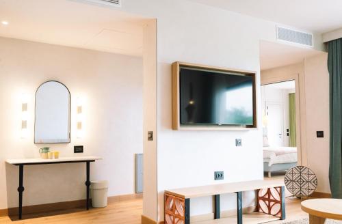a living room with a tv on a wall at A-ROSA Gardasee in Salò