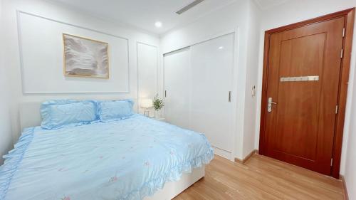 a bedroom with a bed and a wooden door at KABILUX HOUSE - 1-2-3 Bedrooms in Vinhomes Times City in Hanoi