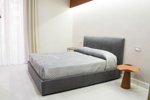 a bedroom with a bed with a gray headboard at Amnis rooms in Salerno