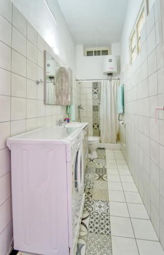 a white bathroom with a sink and a toilet at Waterfront House Pedi in Symi