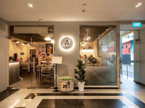 a restaurant with tables and chairs in a building at ibis budget Singapore Imperial in Singapore