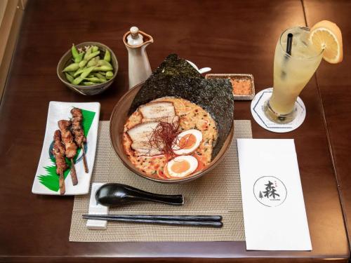a table with a plate of food and a drink at ibis budget Singapore Imperial in Singapore