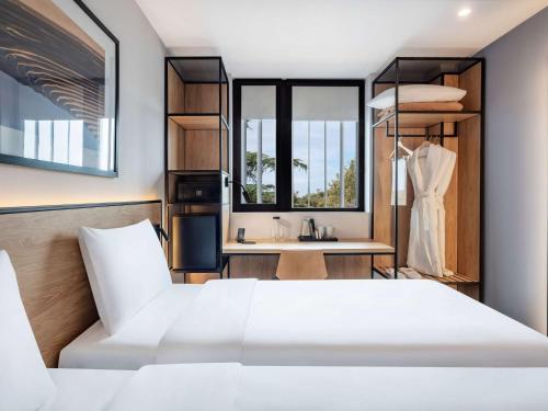 a bedroom with a white bed and a sink at ibis Tbilisi Airport in Tbilisi City