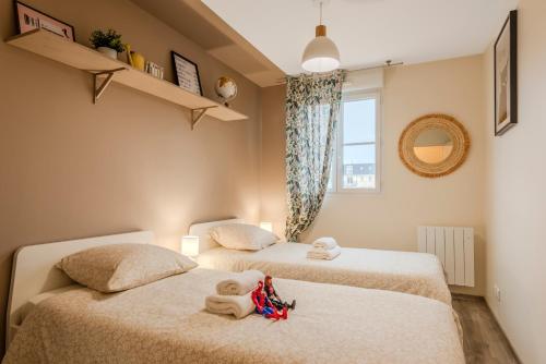 two twin beds in a room with a window at Agora by Kleidos - Bel appartement T3-6 personnes, Disney 10 mn, parking gratuit in Magny-le-Hongre