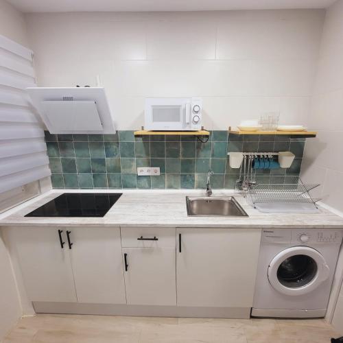 a kitchen with a sink and a washing machine at Precioso Loft con Jacuzzi in Santander