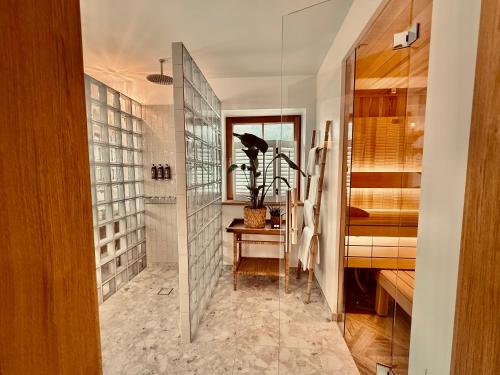 a bathroom with a walk in shower and a glass wall at SEIN Boutique Suites - ADULTS ONLY in Gosau