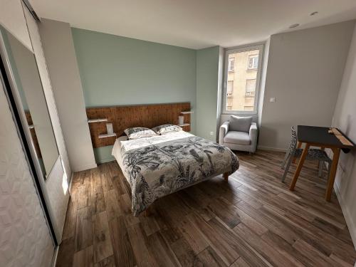 a bedroom with a bed and a desk and a chair at Appart du faubourg in Valence
