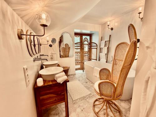 a white bathroom with a tub and a sink and a tub at SEIN Boutique Suites - ADULTS ONLY in Gosau