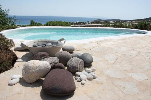 a pile of rocks sitting next to a swimming pool at Hacienda house in Andiparos