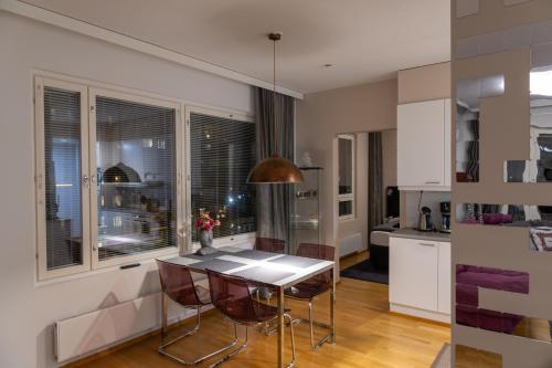Una cocina con una mesa y sillas en una habitación. en Luxury apartment with sauna, grill and garage, en Tampere