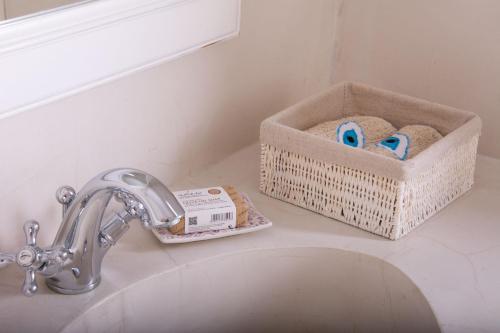 a bathroom sink with a faucet and a basket of towels at Hacienda house in Andiparos