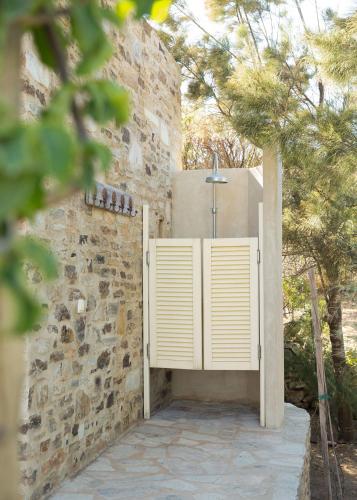 a gate in a stone wall with a cross on it at Hacienda house in Andiparos