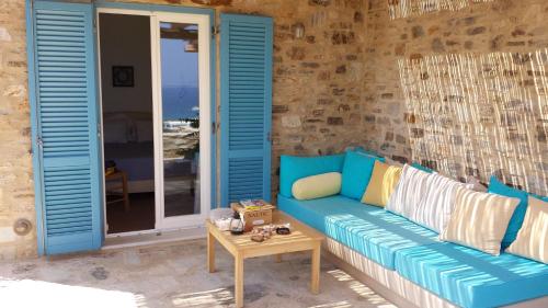 a blue couch on a patio with a table at Hacienda house in Andiparos