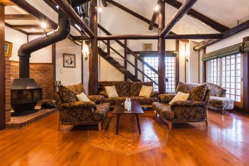 a living room with couches and a fireplace at Hotel Jogakura in Aomori