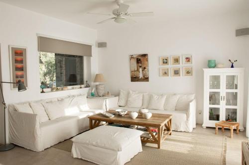 a living room with a white couch and a table at Hacienda house in Andiparos