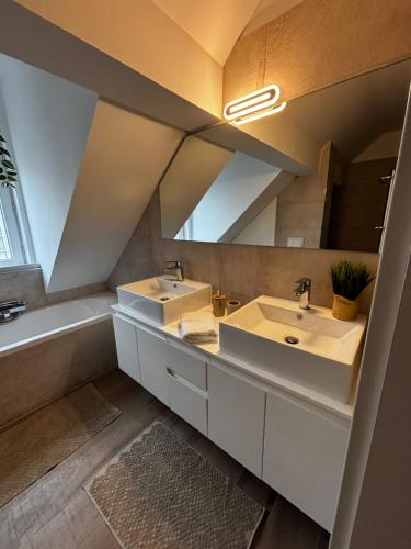 une salle de bain avec deux lavabos et un grand miroir dans l'établissement Lumineux 4 personnes - Strasbourg, à Strasbourg