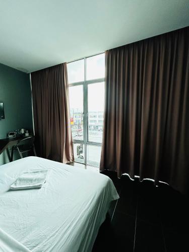 a bedroom with a bed and a large window at DS Hotel in Ipoh