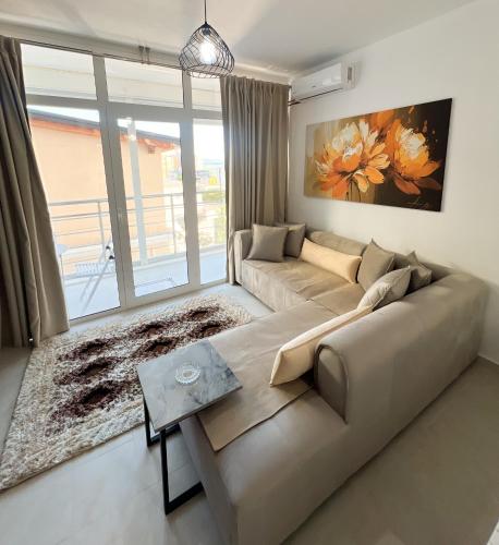 a living room with a couch and a large window at Sea View Apartments in Durrës