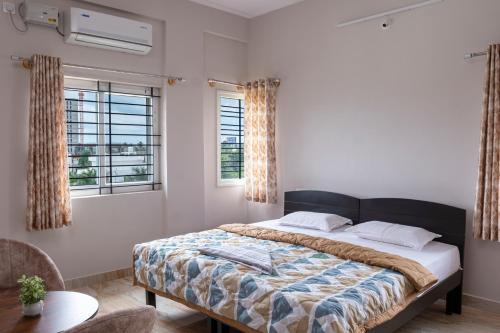 a bedroom with a large bed and two windows at WHITE HOSUE LIVING iNN in Bengaluru