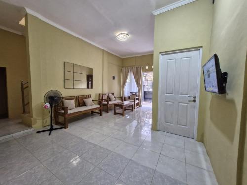 a living room with chairs and a door at Cemara Guesthouse Mataram Lombok in Mataram