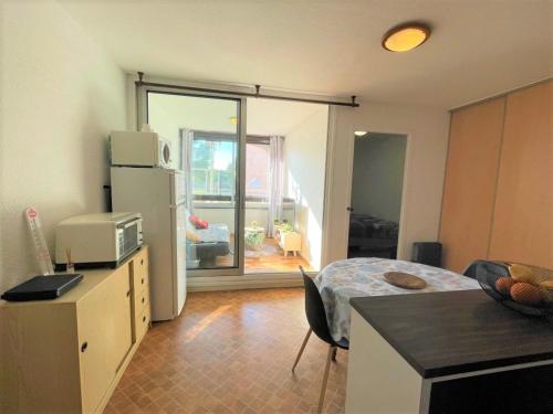 Cette chambre comprend une cuisine équipée d'un réfrigérateur et d'une table. dans l'établissement Appartement 2 pièces 4 couchages ST CYPRIEN PLAGE SC510-38B, à Saint Cyprien Plage