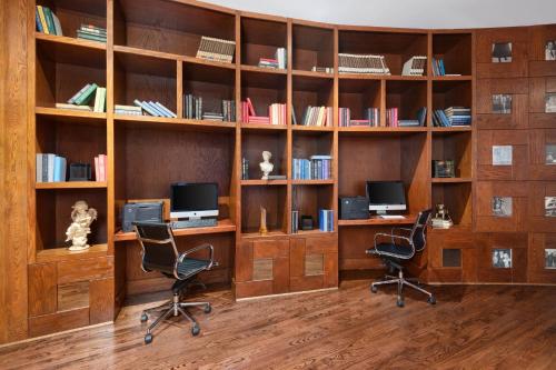a library with two desks and two chairs and books at The Saint Hotel, New Orleans, French Quarter, Autograph Collection in New Orleans