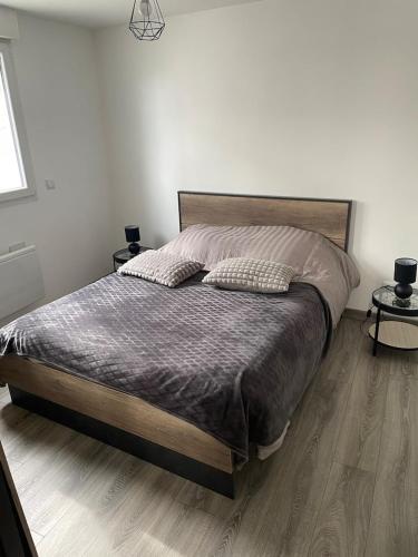 une chambre avec un lit avec deux oreillers dessus dans l'établissement Jolie maison de ville atypique, à Saint-Mariens