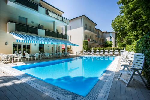 a swimming pool in front of a building at Hotel Athena in Cervia