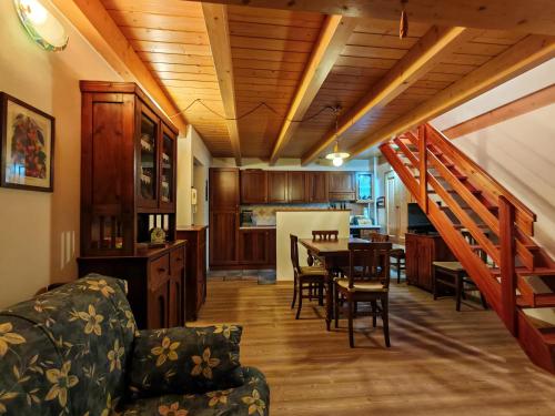a kitchen and living room with a table and a staircase at Val di Sole Family Apartments in Malè