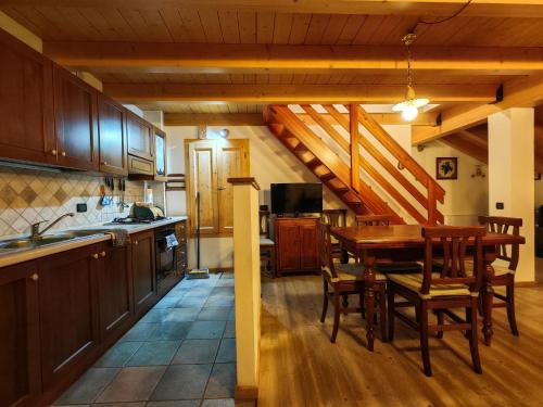 a kitchen with a table and a dining room at Val di Sole Family Apartments in Malè