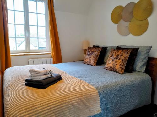 une chambre avec un lit avec des serviettes dessus dans l'établissement kerwatt, à Cabourg
