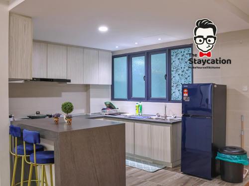 a kitchen with a blue refrigerator and a counter at Staycation Homestay 38 Viva J2 near Tabuan in Kuching
