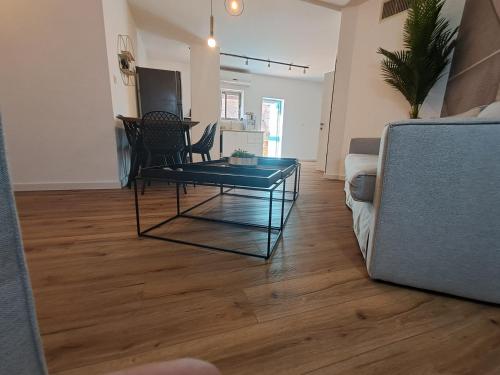a living room with a glass coffee table and a couch at YalaRent Afarsemon Apartments with pool - For Families & Couples in Eilat