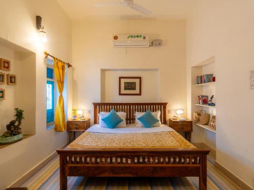 a bedroom with a bed with blue pillows at Moustache Jodhpur in Jodhpur