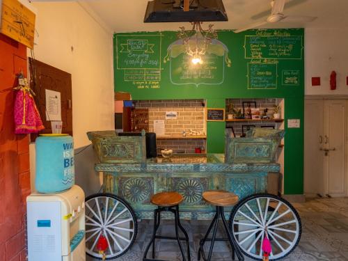 a restaurant with a counter with two stools and a bar at Moustache Jodhpur in Jodhpur